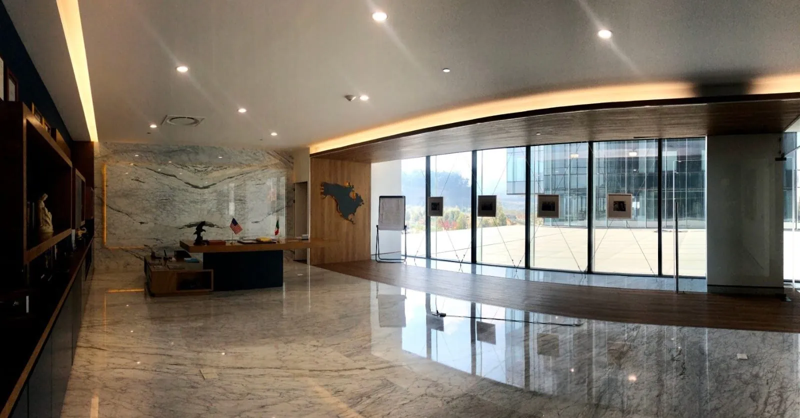 IL HQ: lobby ejecutivo con mármol, madera y ventanal de piso a techo